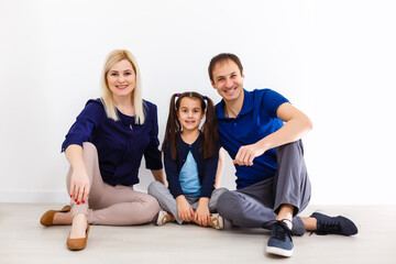 Portrait of happy family of three looking at camera with smiles
