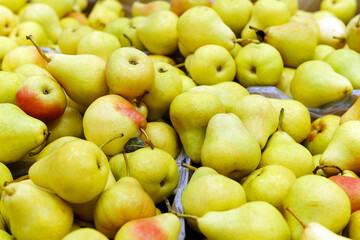 Fresh delicious organic yellow pears on the shelves of the hypermarket background.