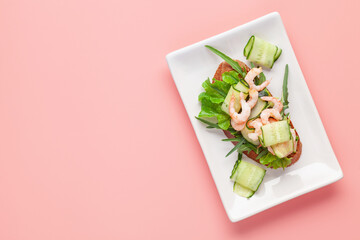 Open sandwich shrimp, cucumber, arugula. Homemade smorrebrod with rye bread. Top view