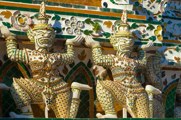 Fototapeta premium Sculptures of Rakshasa demons supporting the main prang of the Temple of the Morning Dawn (Wat Arun). Bangkok, Thailand