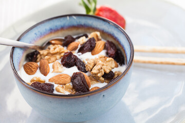 Greek type yoghurt with almons, walnuts, raisins and honey. Healthy vegetarian breakfast.