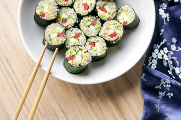 Vegan sushi with chopsticks. Sushi from kinoa with bellpeper, avocado, cucumber