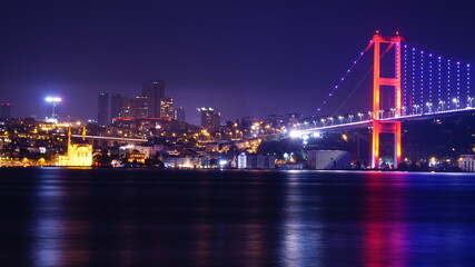 Fototapeta na wymiar Bosphorus bridge at night in Istanbul, navy blue sky and sea