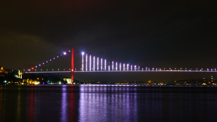 Fototapeta premium Bosphorus bridge at night in Istanbul, navy blue sky and sea