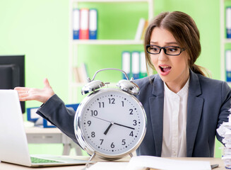 Young female employee very busy with ongoing paperwork in time m