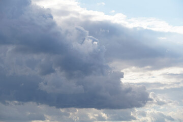 Blue sky on a sunny day with gray white clouds. Nature background.