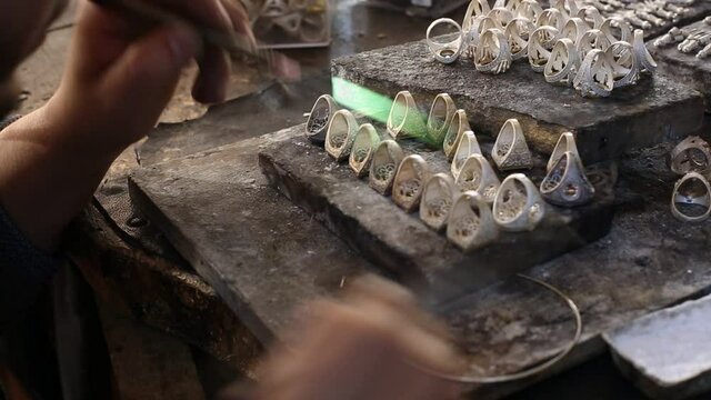 craftsman is making silver rings. Production of silver rings in the jewelry workshop.