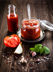 Raw tomatoes and tomato sauce in jar
