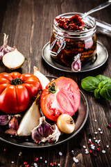 Raw tomatoes and sun dried tomatoes in olive in jar
