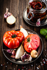 Raw tomatoes and sun dried tomatoes in olive in jar
