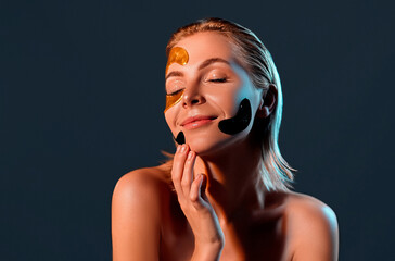 Fototapeta premium Attractive woman with color patches on her face. Portrait of young woman touching hand her face. Skin care concept.