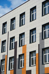 facade of a modern building on a bright Sunny day, siding and Windows, beautiful exterior of the new building