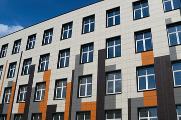 facade of a modern building on a bright Sunny day, siding and Windows, beautiful exterior of the new building