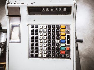 Photo of an old Soviet cash register with buttons and numbers and with paint peeling off from old age on the case