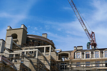 Fototapeta na wymiar modern building under construction, plastered walls and scaffolding, construction crane