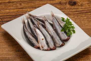Anchovies in the bowl served basil leaves