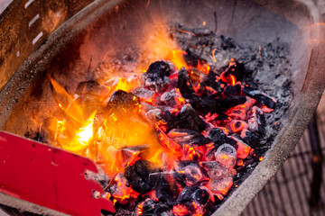 close up burning coals in a barbeque stand
