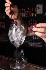 The bartender prepares a cocktail in the restaurant bar. The process of pouring alcohol into a glass.