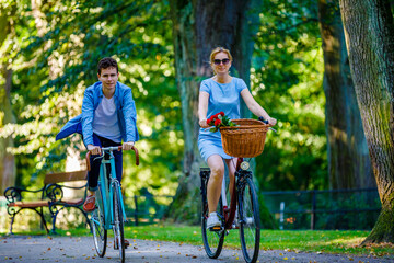 Healthy lifestyle - people riding bicycles in city park
