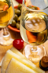 Glasses of dry fino sherry wine served with spanish tapas, manchego cheese, green olives, cheese crackers