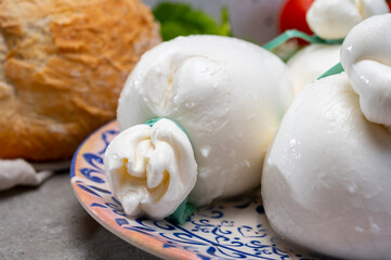 Cheese collection, fresh soft Italian cheese from Puglia, white balls of burrata or burratina cheese made from mozzarella and cream filling