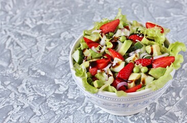 salad with strawberries, avocado, lettuce, onion, green peas. dressed with balsamic sauce.