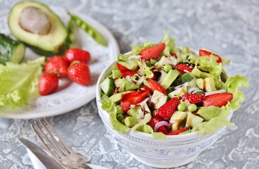 salad with strawberries, avocado, lettuce, onion, green peas. dressed with balsamic sauce.