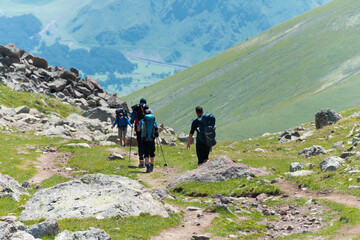 Group of hikers on Mountain range on a hiking trail from Gergeti Trinity Church to Gergeti Glacier. a famous landscape in Kazbegi, Mtskheta-Mtianeti, Georgia.