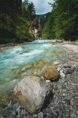 Alpine scene with a blue river an rocks in the foreground and background near wimbach-klamm in Berchtesgarden, Bavaria