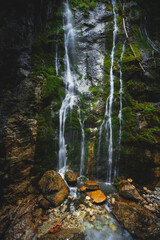 Intimate scene of small waterfall, rocks and moss