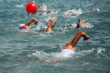Competitors swimming out into open water at the beginning of triathlon