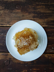 Fresh honeycombs on a plate on a table against a brick wall background