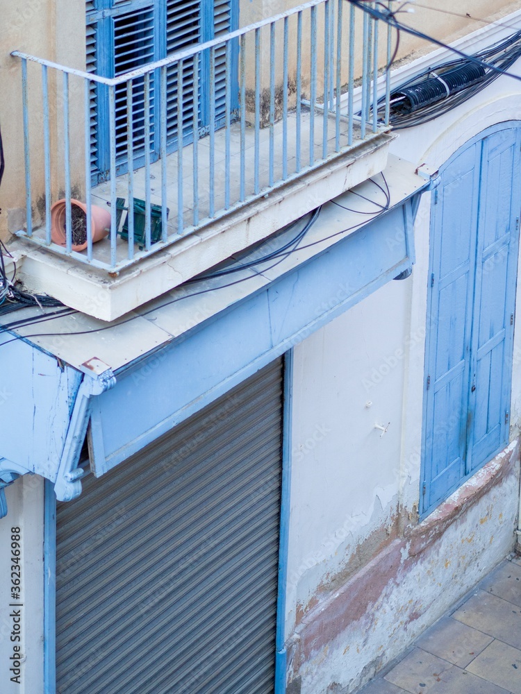 Wall mural Old building with blue doors and windows and a balcony