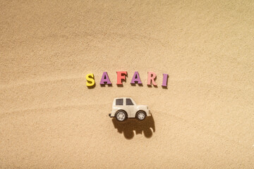 Toy white safari jeep on the sands of the beach, desert dunes. Concept