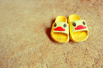 Fototapeta na wymiar yellow Duck Sandals on cement floor
