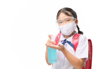 Asian girl student wear face shield and mask holding alcohol gel.