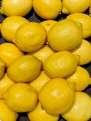 Close-up photo of lemons in market. Fruits background. Texture yellow lemon. 