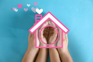 Mother holding hands with child and illustration of house on blue background, top view. Adoption...