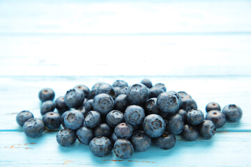 Tasty blueberries on blue background. Blueberries are antioxidant organic superfood.