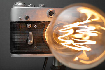 Retro lamp from an old camera with an Edison lamp on a gray background. Concept is a good idea.