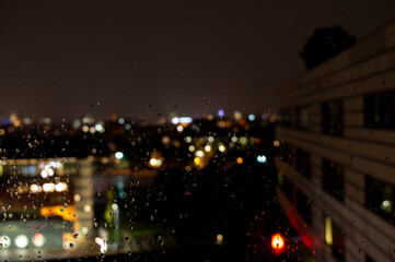 Raindrops on window with a nightly city scape in the background
