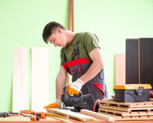Young man carpenter working in workshop