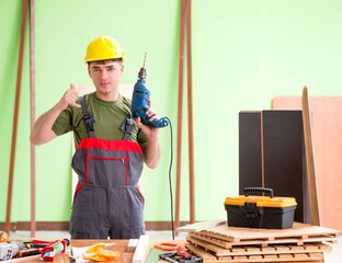 Young man carpenter working in workshop