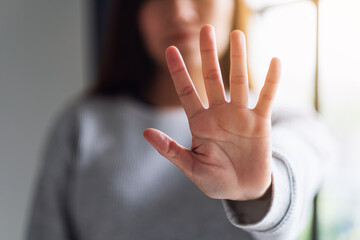 Closeup image of a woman outstretched hand and showing stop hand sign