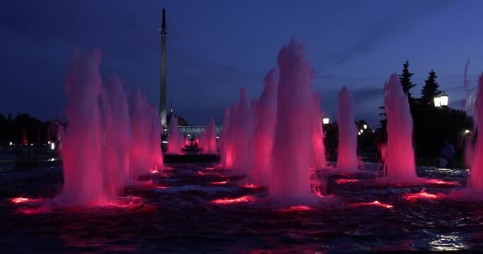 red fountains with backlight, large in the dark, 4k