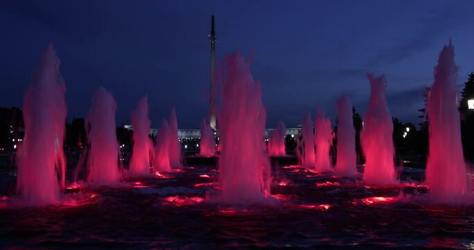 red fountains with backlight, large in the dark, 4k