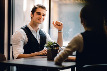 Happy Businessman Smiling while Meeting with his Partnership or Teamwork in Cafe or Creative Workplace. Relaxing and Comfortable Posture