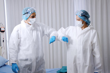 Powerful and energy of Medical team in Personal Protective Equipment or PPE clothing and Healing for patient infected with the Covid-19 virus is Elbow and arms collide in hospital of Thailand