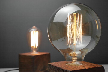 Retro wood lamp with Edison lamp on a gray background. The concept is a good idea.