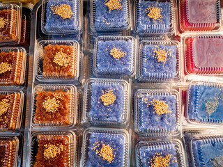 Purple Thai Desserts with Sesame are in a Rectangular Plastic Box